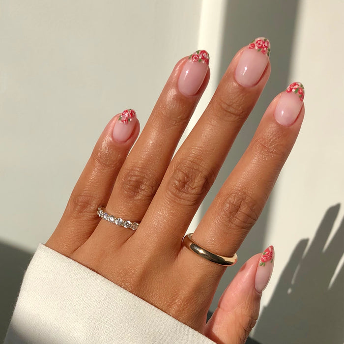 Dream sheer pink nail polish with brown French tip nail art and rings in sunlight