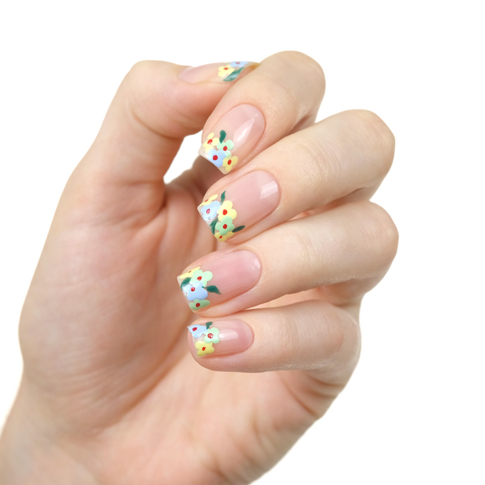 Bare sheer nude nail polish with tiny daisy accent nail art on a light skin tone