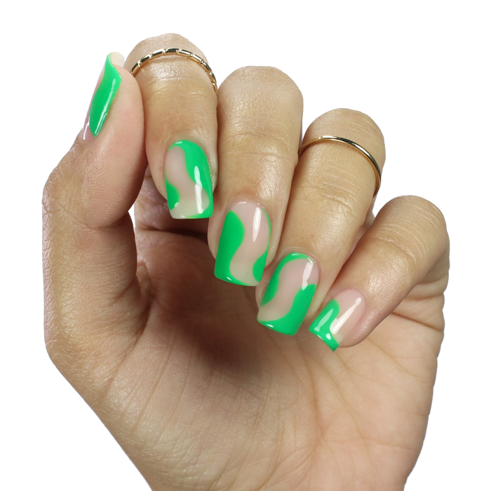 Bare sheer nude nail polish with neon green swirl nail art on a medium skin tone