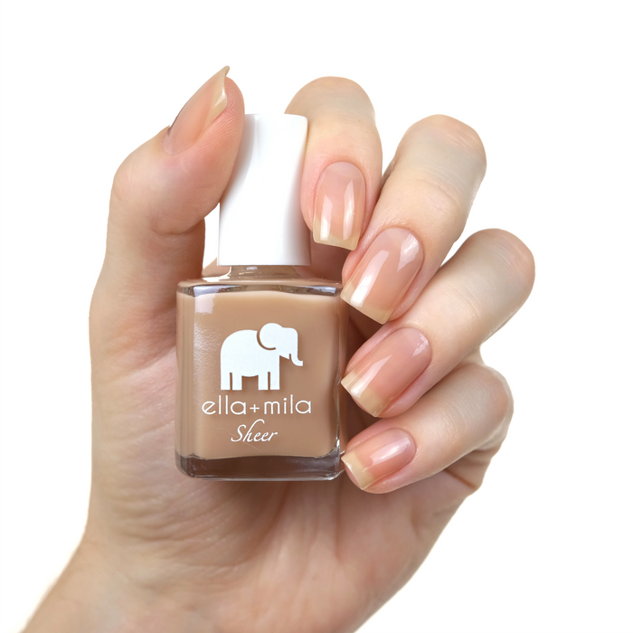 Beloved sheer nude brown nail polish manicure on a light skin tone with the bottle