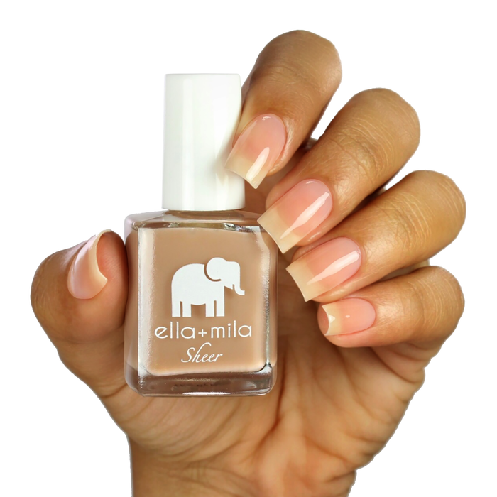 Beloved sheer nude brown tint nail polish on a medium skin tone, hand holding the bottle