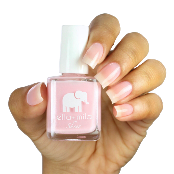 Dream sheer baby pink tint nail polish on a medium skin tone, hand holding the bottle