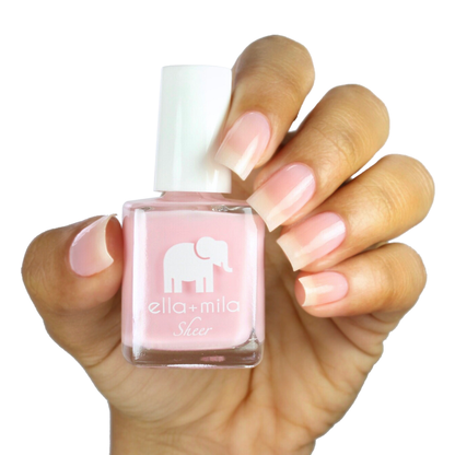 Dream sheer baby pink tint nail polish on a medium skin tone, hand holding the bottle