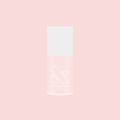 Bottle of FIRST DATE nail polish in soft milky strawberry pink with subtle silver shimmer on a pink background