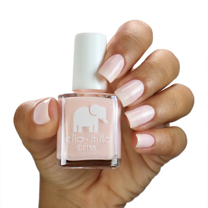 La La Land nude pink nail polish on a medium skin tone, hand holding the bottle
