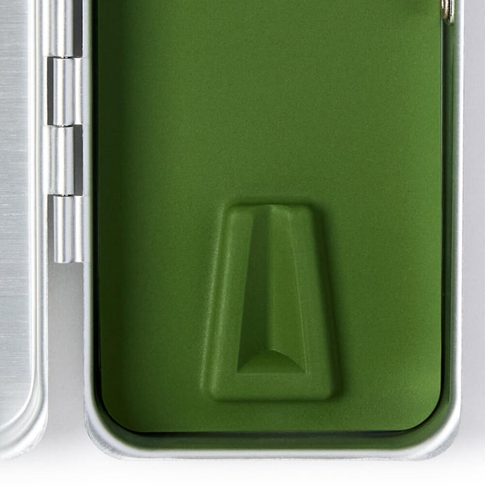 Close-up of a green silicone insert in the silver Leaf Razor travel case