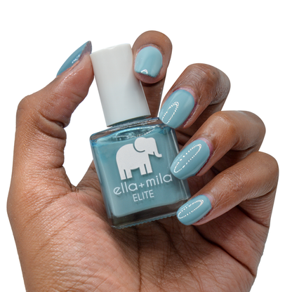 Window Seat grey blue nail polish on a deep skin tone, hand holding the bottle