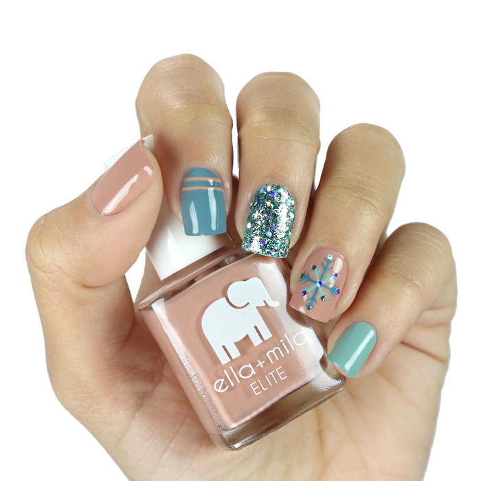 Window Seat grey blue and nude nail polish with a silver glitter accent nail, holding the bottle